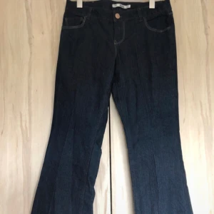 Low waist jeans - Ett par assnygga mörkblåa bootcut jeans med låg midja. Säljer pga har ett par liknande. Måtten är: midjan 42cm, innerbenslängd: 82cm, bredd på benen längst ned: 25cm. Byxan har stretch. Sömmen längst ned är uppsprättad men annars ny kvalitet. 