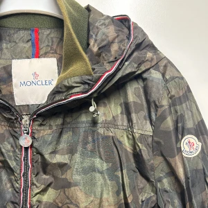 Moncler jacka - Kamouflage Moncler jacka, är som en vindjacka så det passar bra till våren och även under sommaren! Jätte bra skick, finns qr kod inuti, äkta! Skriv för mer bilder osv 
