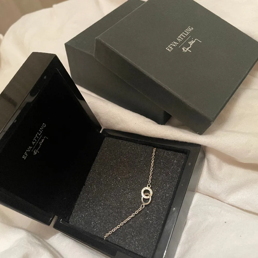 Super fint Efva attling armband i silver. Fint skick! Nypris 1400kr Mitt pris 500kr ”Armband i återvunnet sterlingsilver med två sammanlänkade ringar. En rundad ring och en kantig med orden ”Amor Vincit Omnia” - kärleken övervinner allt på latin.”. Asusteet.