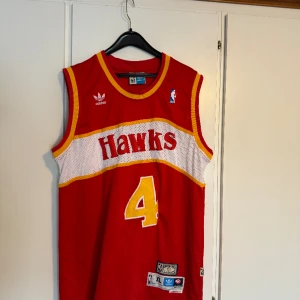 SPUD WEBB BASKETLINNE - Säljer nu mitt Spud Webb linne från tiden när han spelade i Hawks! Bra skick då jag inte använt så mycket, köpt i en vintagebutik i Stockholm för 600kr. Storleken är XL men passar absolut M/L som jag är!
