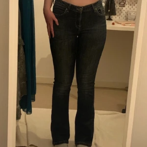 mörkblå, lågmidjade, utsvängda jeans - Mörkblå, lågmidjade, utsvängda jeans. Jag vet inte riktigt vilket märke eller storlek, då lappen är bortklippt. Jag uppskattar dock att de är typ storlek 36 för att de passar mig som vanligtvis bär 36.