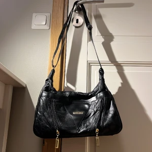 skinnväska - jättesnygg väska som tyvärr inte kommit till användning.. har 8 fickor och en axelrem som kan justeras så man kan bära den på olika sätt! är köpt second hand men är i rätt bra skick