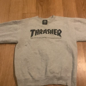 Grå thrasher tröja i ny skick is storlek S. Obs något liten i storlek se mått på bilderna. Ny pris ligger på 900kr - Ny skick