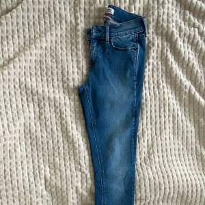 Ett par mörkblåa jeans från Tommy Hilfiger. De är i väldigt bra skick och är som nya. Endast använd ett få tal gånger. Jeansen är mid rise och skinny.   Vid intresse, skriv!❤️ Kan även då skicka bättre och mer detaljerade bilder på jeansen. 