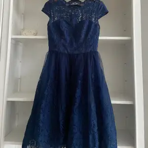Jättefin cocktailklänning i marinblå färg. Underdelen är i tyll så det blir ett väldigt fint fall på klänningen! Använd 1 gång. 