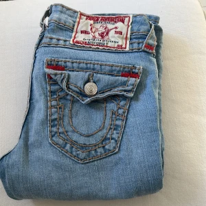 Lågmidjade True Religion jeans - Lågmidjade Raka True Religion jeans, men sitter som bootcut. Aldrig använda så i väldigt fint skick. I storlek 26 ( passar mig i längden som är 170) orginal pris 2500kr