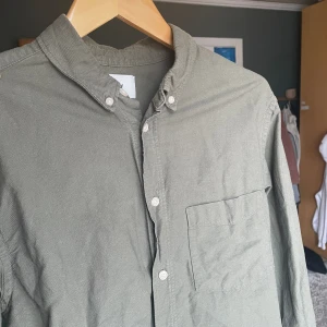 Militärgrön skjorta! - En snygg militärgrön skjorta från H&M i strl M Den är i jättebra skick och har blivit använd några gånger! Skriv gärna med frågor!