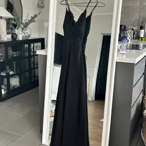 Svart jumpsuit - En otroligt fin jumpsuit med fina detaljer på bröstet. Öppen rygg med X band. Nyskick.
