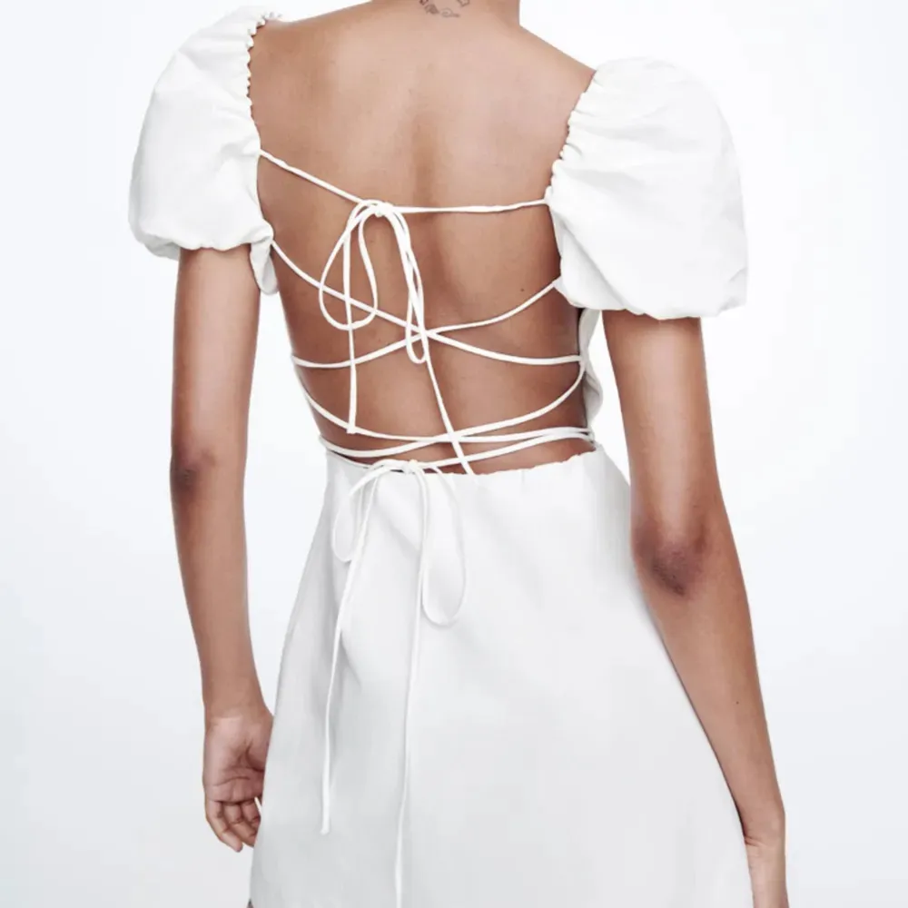 Säljer denna vita zara klänningen med öppen rygg då den inte passar längre.  Den har endast använts en gång i någon timme och är därför som ny.. Klänningar.