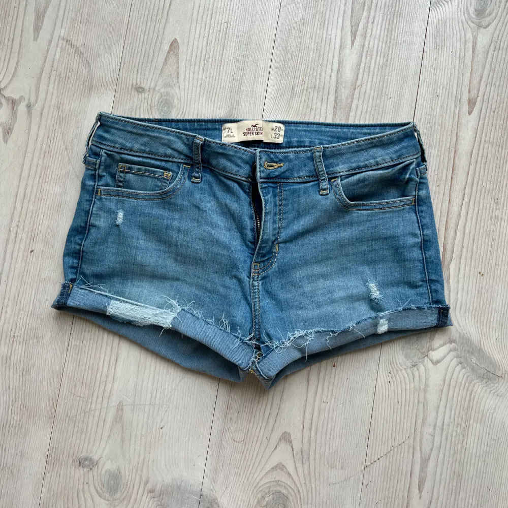 Ljusblå lågmidjade jeansshorts från Hollister i storlek W28 L33 som jag har gjort om från ett par byxor. Tvärs över midjan är det ca 39 cm. Passar mig som brukar ha S eller M. Fint skick. Använd gärna köp nu!. Shorts.