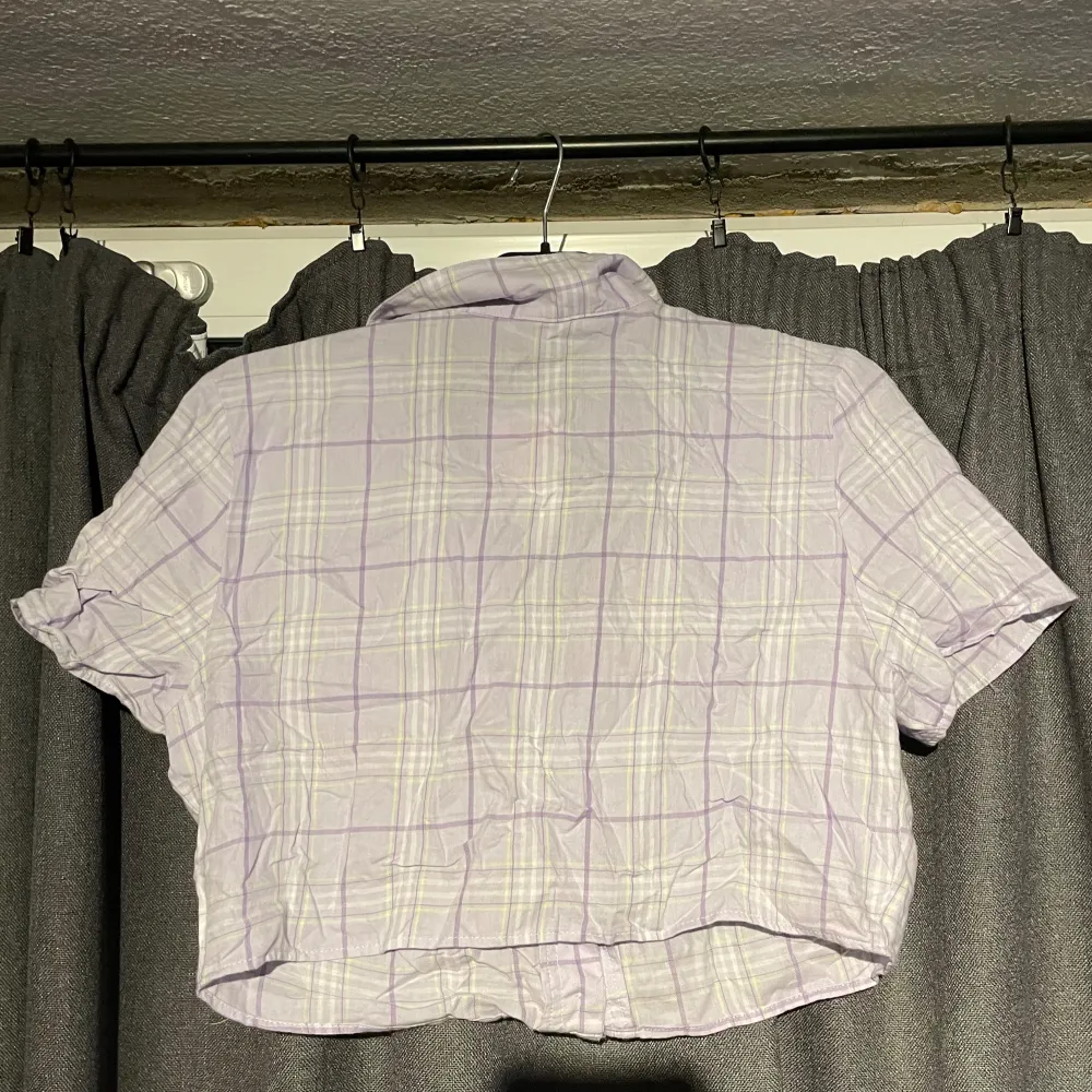 Väldigt kort lila rutig skjorta, aldrig använd helt ny med lapp. Blusar.