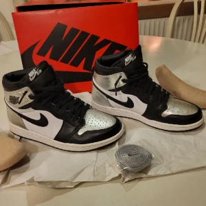 Air Jordan 1 Retro High OG ‘Silver Toe’ - Nya jordans i kartong Inköpta i september för 3400kr. Ej använda tills nu och nu har jag tyvärr växt ur dem. Försökte returnera men tiden har utgått. Följer med extra orginal skosnören i silver. Säljes fyndpris se nedan