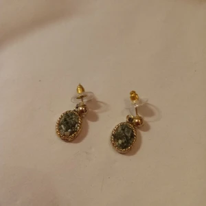 Örhängen med hänge av medaljong gröna stenar guldfärgad . - Fina gamla vintage örhängen med hänge av en medaljong med gröna stenar guldfärgad .