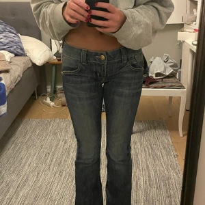 Lågmidjade jeans  - Jättesnygga lågmidjade jeans från Guess med coola fickor. Använda lite med de känns som nyskick, väldigt bra kvalite! De är lite utsvängda och väldigt långa i benen! ca 85 i innebenslängd. Midjemåttet är 38 cm