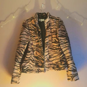 Fleecejacka i tigermönster - Tigermönstrad jacka. Köpt vintage. Märkt med storlek 44, men jag uppskattar den som storlek 42 (jag har storlek S).