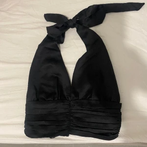 Svart topp - Skit snygg svart topp med knyting runt halsen och knappar backtill, perfekt festopp😍