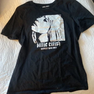 Billie eilish merch - En svart t-shirt med billie eilish tryck på!! Merch ifrån henne ifrån hennes album Happier Than Ever. Står storlek 14-15 år och är oversized. Så den passar i princip alla bero de på hur man vill att den ska sitt. 