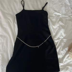 En svart fin klänning med ett kroppssmycke av silver (justerbar) 