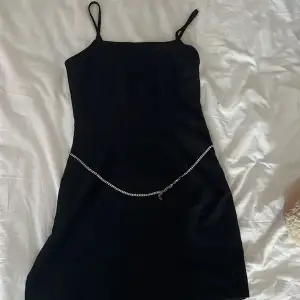 En svart fin klänning med ett kroppssmycke av silver (justerbar) 