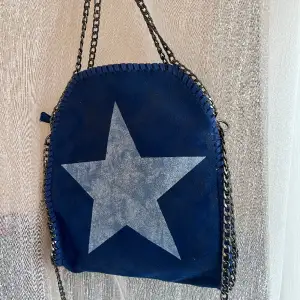 En mörkblå väska med en vit stjärna på framsidan, superfin!! Säljer pga kommer ej till användning.