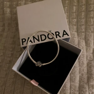 PANDORA BERLOCKARMBAND  - Ett helt nytt berlockarmband från Pandora. Fick i present men då jag redan har en sen innan så står den bara och dammar.  Inga berlocker medföljer förutom hjärtat med livetsträd i som syns på bilden. 