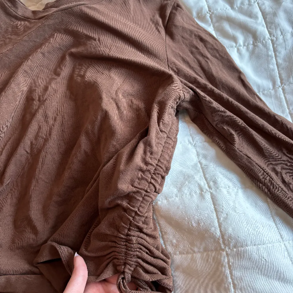 Långärmad brun tröja med justerbar midja, det står att den är i S men jag hade mer sakt att den är en M. T-shirts.