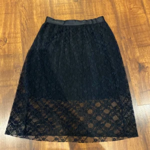 Spetskjol strl 42 - Svart spetskjol med inbyggd underkjol. Från märket object. Strl 42. 