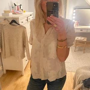 Blus  - Säljer denna beiga blus med puffärm och ett broderat mönster. Storlek 44 men passar mig som bär S.