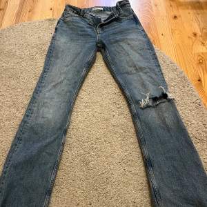 Blåa jeans med slitning på ena knät💗 från Gina i storlek 34