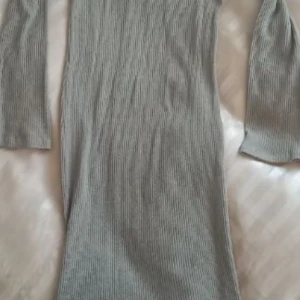 GinaTricot klänning  - Jag säljer min långklänning från GinaTricot pga av att färgen inte passar mig. Den är har färgen beige och är i mjuk ribbad kvalitet. Använd endast en gång. Pris: 75 kr Nypris 150 kr