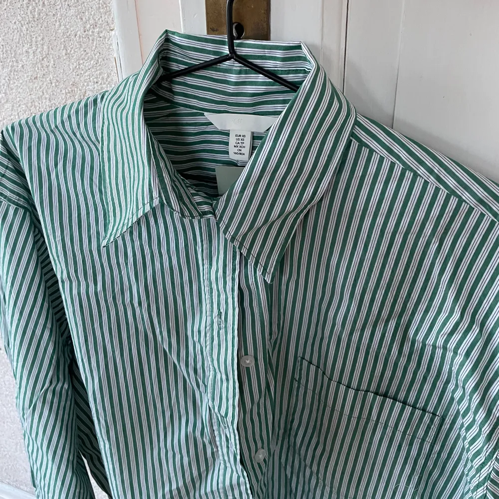 storlek xs men väldigt oversize. grön- och vitrandig. aldrig använd, lappen kvar. jag står för frakt :). Skjortor.
