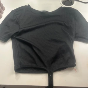 T-shirt med snöre - Hej, säljer en jättefin t-shirt med ett ganska långt snöre som man ska knyta. Använd en gång till fest, men annars aldrig använd och är som ny ❤️❤️