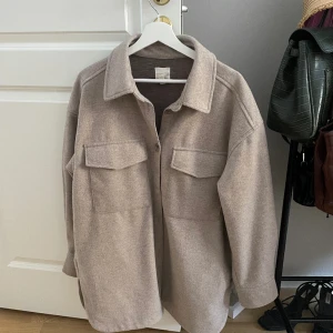 Vårjacka - Beige filtjacka perfekt till våren, strl L, sitter oversized på mig som är en M. Sparsamt använd! 