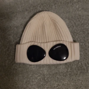 CP Company Mössa - Jag har en CP Company-mössa i vitt som bara har använts en gång. Jag säljer min CP Company mössa för 900 då den är i otroligt bra skick och ser nästan helt ny ut. Med sitt stilrena utseende och högkvalitativa material kommer du se riktigt fräsh ut.