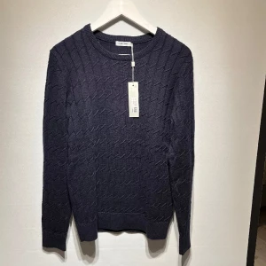 Kabelstickad tröja J Lindeberg - Säljer en helt ny stickad tröja från J Lindeberg med lapparna kvar, endast testad. Inga defekter eller skador. Riktigt snygg över en vit skjorta till ett par jeans. Storlek small