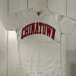 Chinatown T-shirt - Chinatown T-shirt i vit, säljs på grund av att den är för liten!