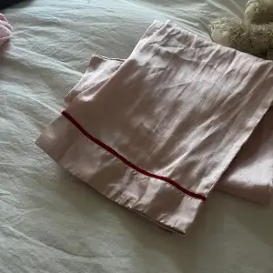 Rosa pjamasbyxor i siden med röd detalj längst ner💕💕 bra skick!!! Jag är 167 cm och de är i bra längd De är mera ljusrosa i verkligheten☺️