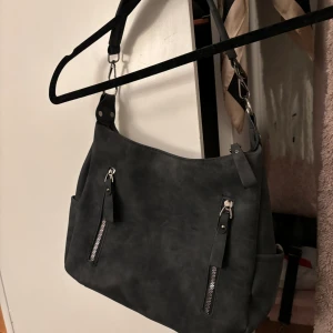 Väska  - En söt väska som är lite större. Får inte plats en dator i men större än en vanlig handväska. Aldrig använd. Bra skick. Finns ett stort fack och tre mindre, varav en men dragkedja. 