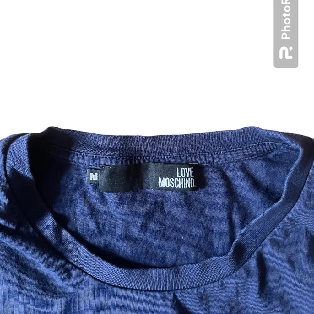 En snygg Blå Love Moschino T shirt i storlek M sitter ganska Slim och har inga defekter eller fläckar skriv gärna om ni har några ytterligare frågor😷🫶. T-shirts.