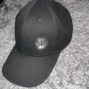 Äkta philipp plein keps  - Kanhända några gånger. Inte solblekt. Passar M   Beställnings kvitto finns, köpte den slutet av förra sommaren.  Skick: använd men som ny. Ny pris: 2600kr  
