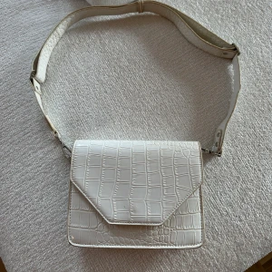 Vit Ormskinn Axelremsväska - Vit ormskinnsmönstrad axelremsväska. Perfekt väskan! 🔥bra med fack och axelremsband. Använd men bra skick 🫶🏼.