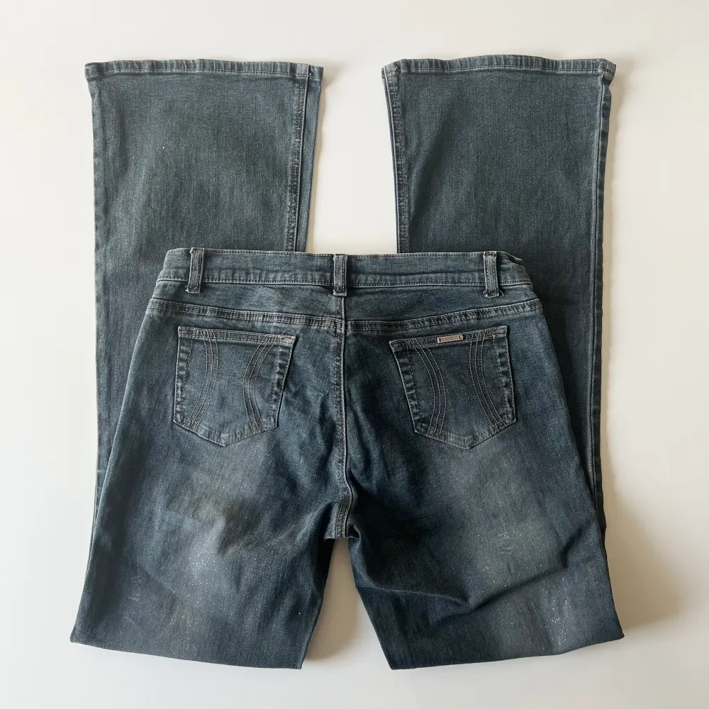 Vintage svarta / mörkblåa lågmidjade bootcut jeans från River Island med glitter på. Midjemått: 76-80 cm, stretchiga. Innerbenslängd: 79 cm. Storlel 12, passar M. Inga defekter. Modellen är 167 cm lång. Skriv privat för mer bilder och mått! 💕. Jeans & Byxor.