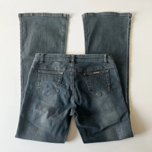 Lågmidjade jeans - Vintage svarta / mörkblåa lågmidjade bootcut jeans från River Island med glitter på. Midjemått: 76-80 cm, stretchiga. Innerbenslängd: 79 cm. Storlel 12, passar M. Inga defekter. Modellen är 167 cm lång. Skriv privat för mer bilder och mått! 💕