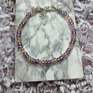 Lila armband  - Lila armband med ”stål tråd” (typ), den går att justera. För mer bilder och information, skriv till mig.