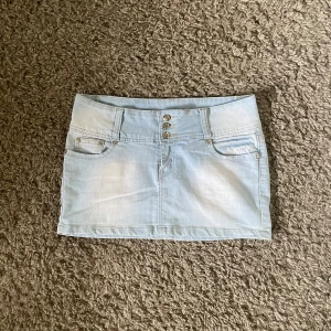 Lågmidjad jeanskjol  - Så snygg lågmidjad jeanskjol!! Midjemåttet: ca 41 cm, längd fram: ca 28 cm, längd bak: ca 31 cm