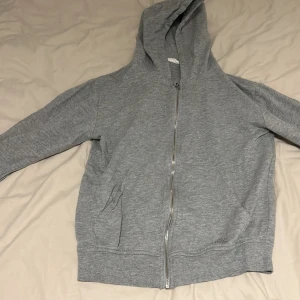 Grå hoodie - En fin grå hoodie. Den är i fint skick utan att den ha en liten röd fläck på backsidan av höger arm. Och ett litet streck på samma arm se bild 2-3. Skriv för fler bilder💕