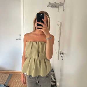 Topp från Dagmar  - Supersnygg topp från Dagmar i en superfin ljusgrön/olivfärg. Snygg med kostymbyxor eller svart kjol eller med en långkjol och klä upp till finare tillställningar. 