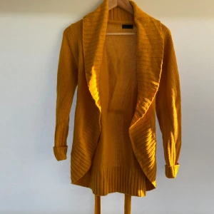 Vero Moda kofta - En varm och bekväm mörkgul stickad kofta från Vero Moda. Knappt använd. Storlek: M. Hör av er vid eventuella frågor!!