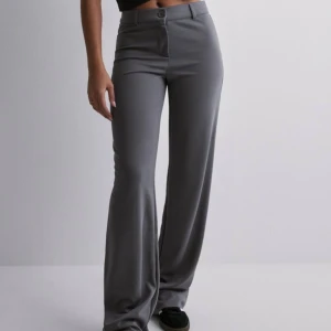 Low waist suit pants - Sköna och snygga byxor från Nelly! Använda en gång. Säljer för att de var lite för stora för mig. Nypris 399kr