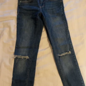 Lågmidjade jeans  - Jeans med slitning/hål på knäna från Gina Tricot. Dessa är låga i midjan och sitter superfint! Är i fint skick, inga defekter. 🌸